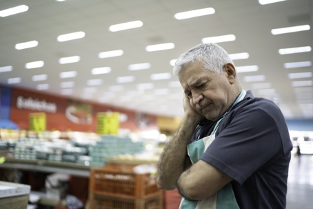 sad retail worker in grocery store